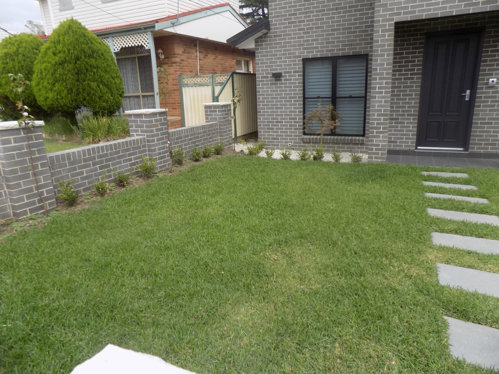 A new front lawn with a stepping-stone path to the front door