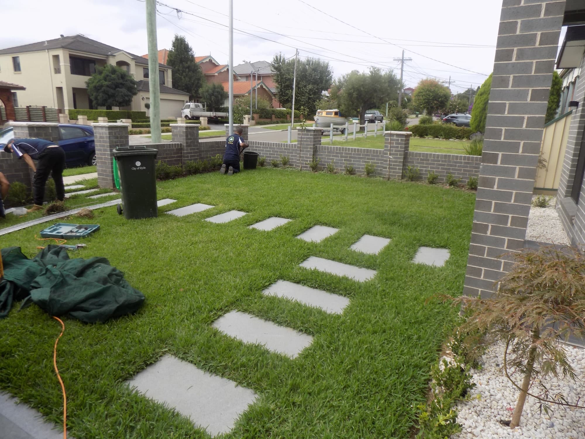 The crew finishing the new front lawn and stepping-stone path